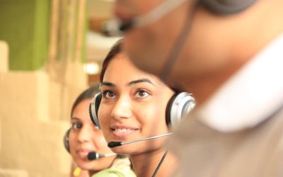 woman in black headphones holding black and silver headphones